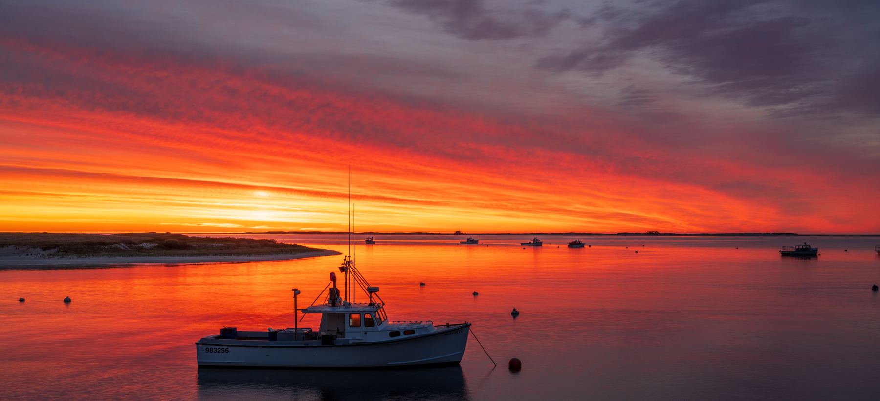 A lobster boat on its mooring in a Cape Cod harbour at sunrise.